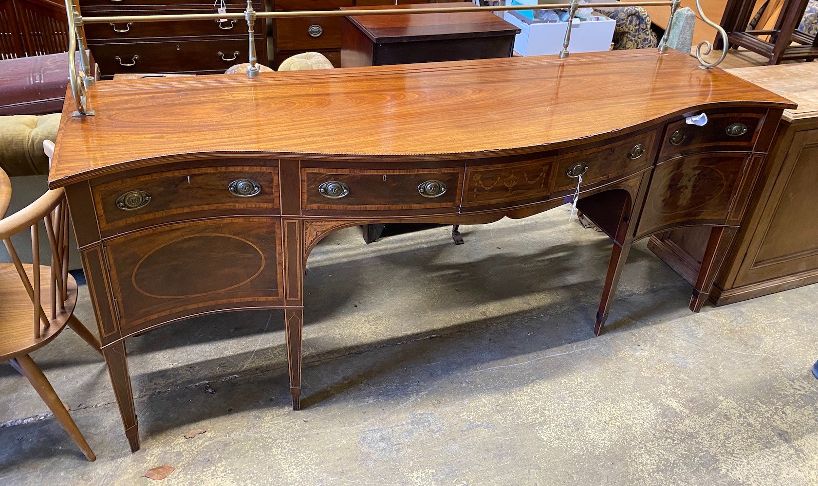 A George III style marquetry inlaid satinwood banded mahogany serpentine sideboard, with brass galleried back, width 214cm, depth 67cm, height 132cm